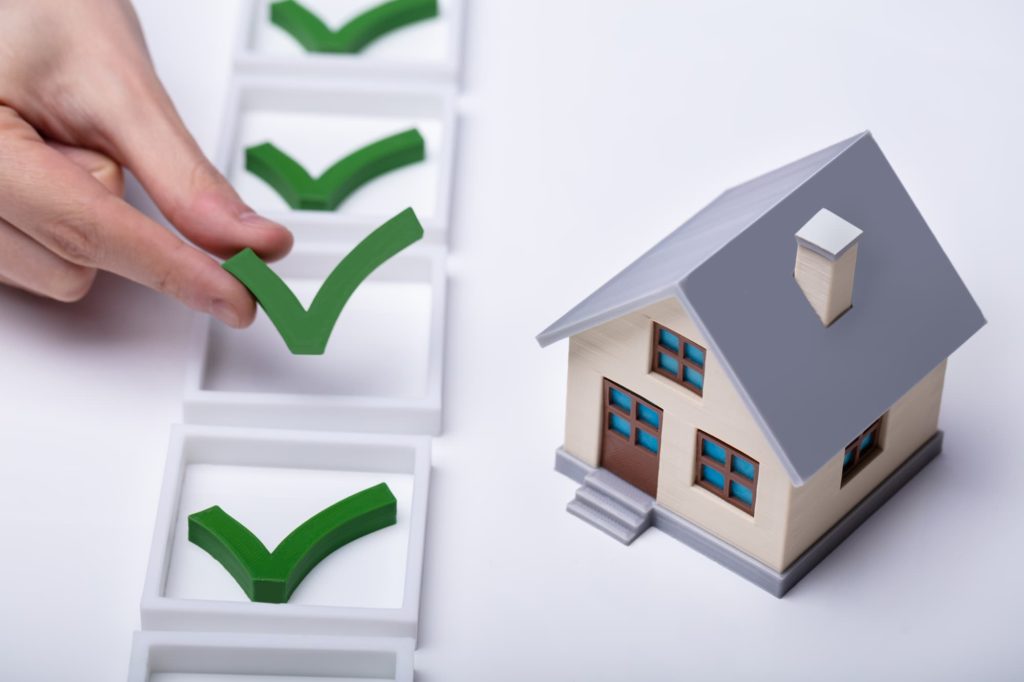 Small model of a home with a checklist next to it